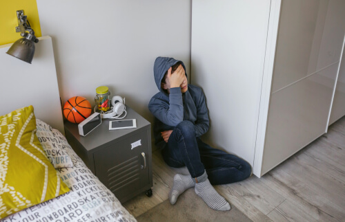 Depressed teenager sat in bedroom